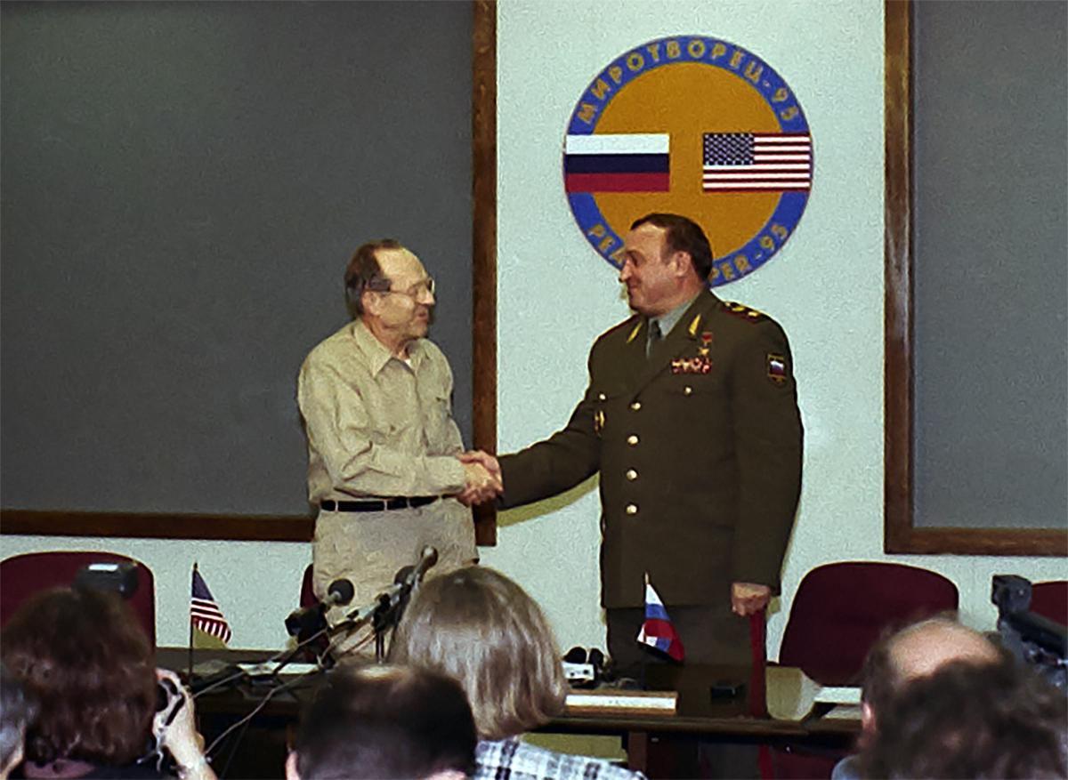 Perry and Grachev standing and shaking hands at Fort Riley.