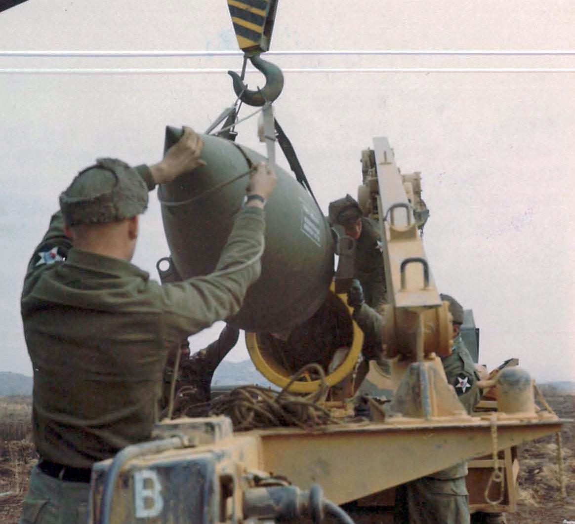 Members of the Headquarters Battery, 1st Battalion, 12th Artillery, 2nd Infantry Division hoisting the warhead section