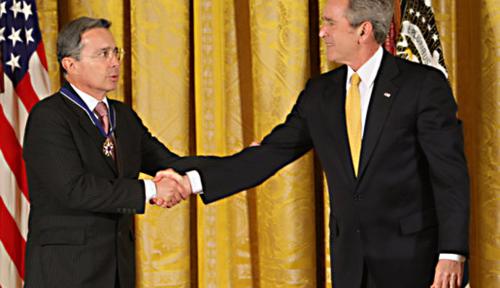 President George W. Bush congratulates President Alvaro Uribe of Colombia after presenting him with the 2009 Presidential Medal of Freedom Tuesday, Jan. 13, 2009, during ceremonies in the East Room of the White House