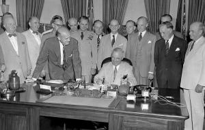 President Harry S. Truman at his desk in the Oval Office signing H.R. 5632, the National Security Act Amendments of 1949, August 10, 1949