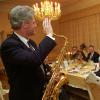 President Bill Clinton, holding a tenor saxophone, waves to a Boris Yeltsin 