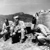 three Manhattan Project specialists use Geiger counters to measure residual radioactivity