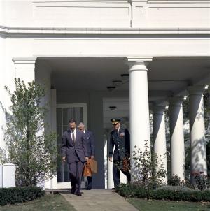 Secretary of Defense Robert S. McNamara (left), Assistant Secretary of Defense for International Security Affairs Paul Nitze (partially hidden), and Chairman of the Joint Chiefs of Staff General Maxwell D. Taylor leave the White House after meeting with President John F. Kennedy and other members of the Executive Committee of the National Security Council (EXCOMM) regarding the crisis in Cuba. West Wing Colonnade, White House, Washington, D.C.