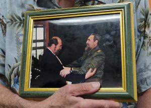 Smith holding photo of himself and Fidel