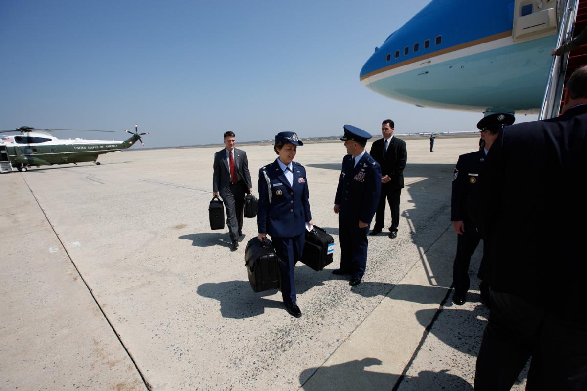 Air Force One readies for departure from Andrews Air Force Base for Waco, Texas, 10 April 2008. Military Aide Lt. Colonel Gina Humble carries the Football. 