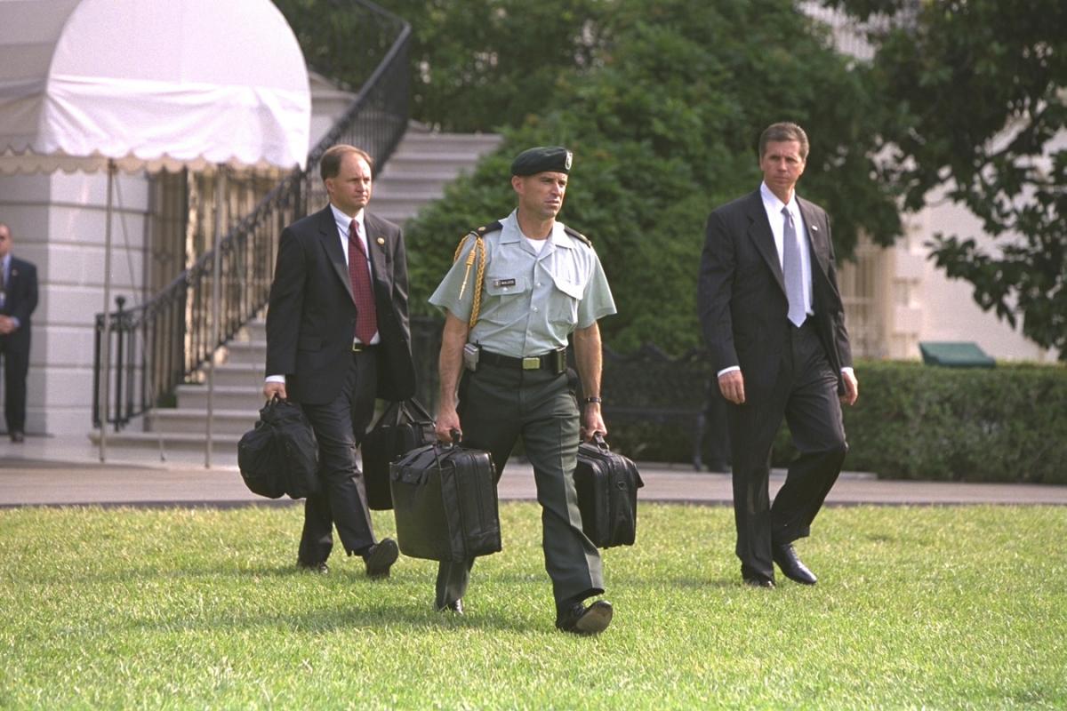  President Bush departs for New York City with Military Aide Major Jim McAllister carrying the Football across the South Lawn to Marine One, 9 July 2002. Photo number P19483-15