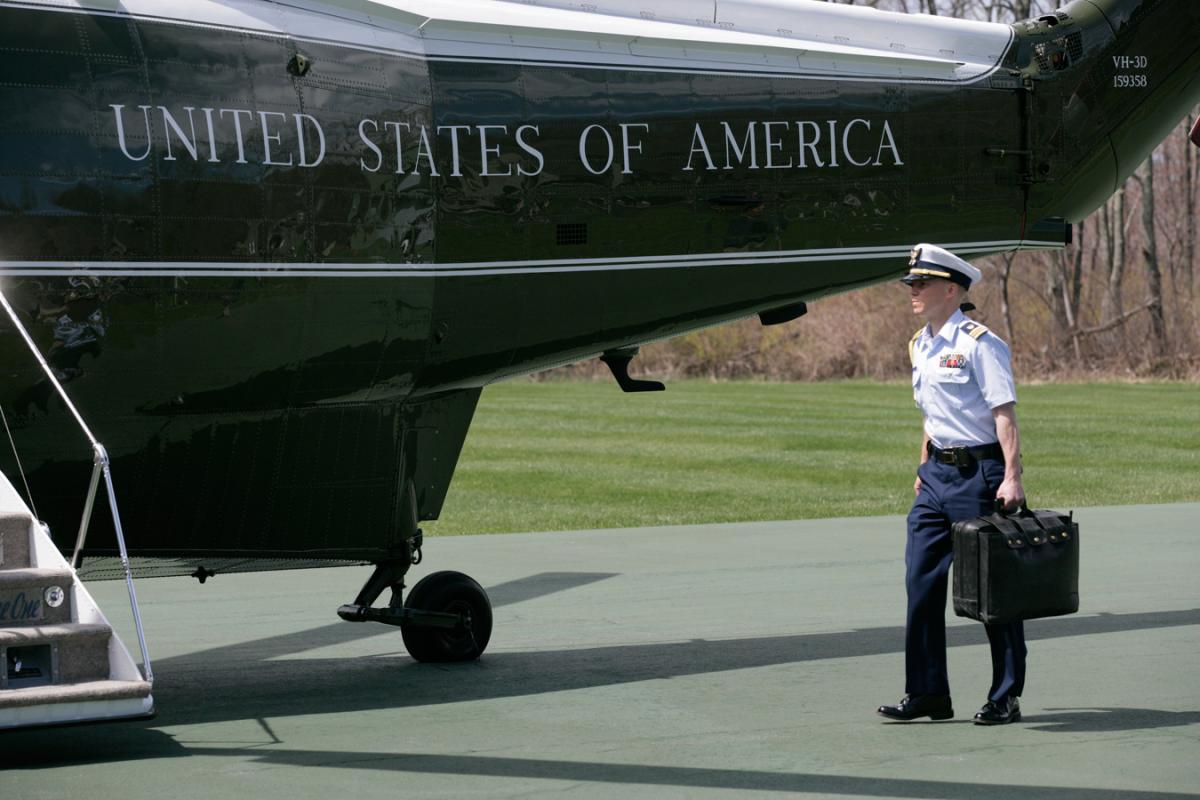 A military aide carries the Football at the Camp David Landing Zone, 16 April 2006, en route to Washington. 