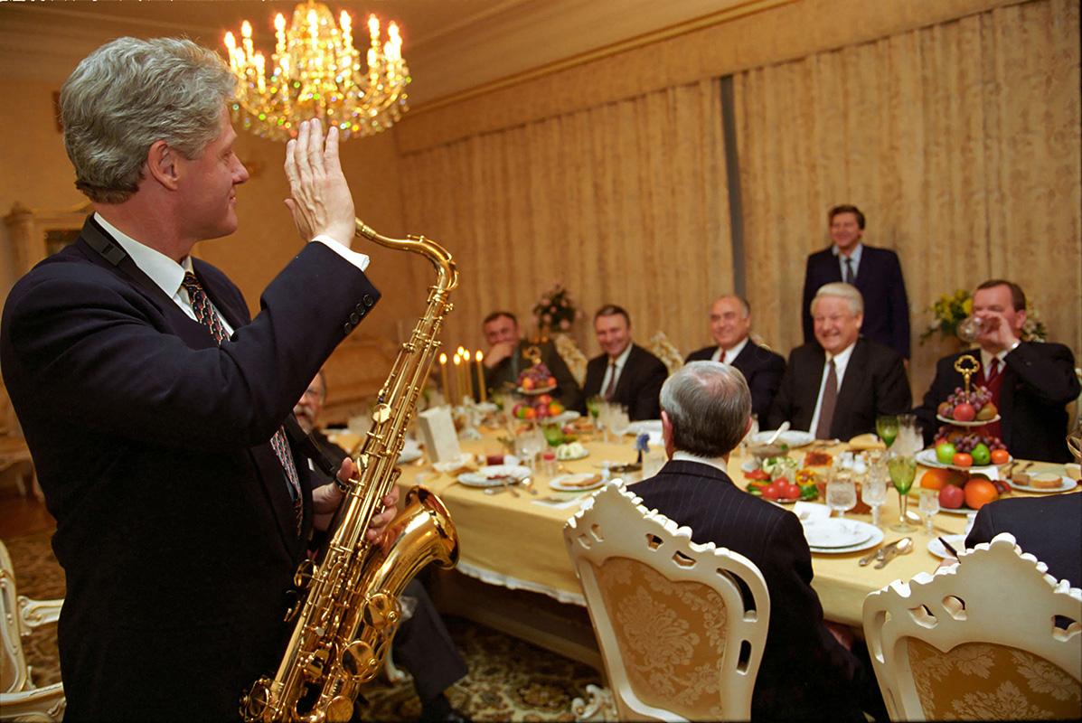 President Bill Clinton, holding a tenor saxophone, waves to a Boris Yeltsin 