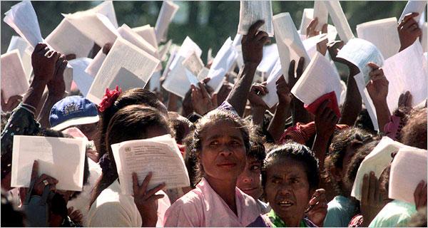 On Aug. 30, 1999, citizens near Dili, East Timor, waved registration papers before a vote on independence. Credit Charles Dharapak/Associated Press