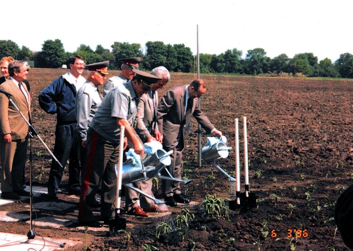 Defense ministers from the U.S. (Perry), Ukraine (Shmarov), and Russia (Grachev) water newly planted sunflowers in 1996 at Pervomaysk, Ukraine, where an ICBM silo once stood